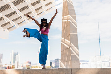 Black woman on roller skates riding outside on urban street. Modern woman posing on roller skates..