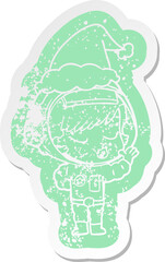 cartoon distressed sticker of a pretty astronaut girl wearing santa hat