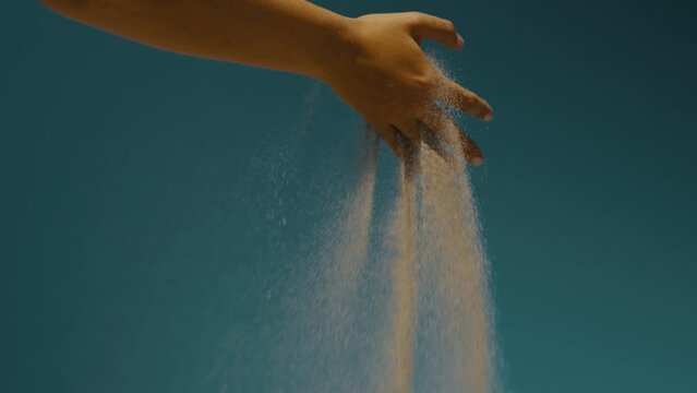 Sand Drifting On A Person's Hand On The Air. Slow Motion