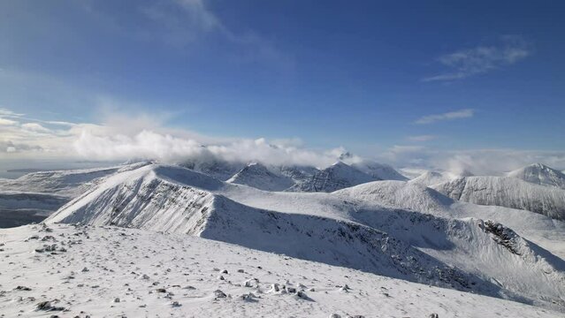 Drone dolley tilt shot of a great view on the Cuillin Mountains covered with snow on Isle of Skye.