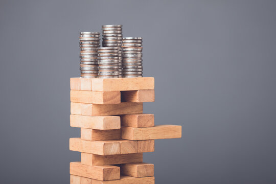 Risks in business or financial concept. Idea to prevent risk in business. Business man playing and selective right or risky piece of tower wooden block game and prevent falling down.