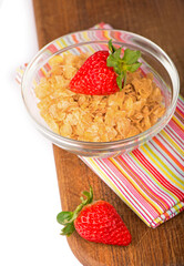Yogurt bowl with fresh sliced strawberries and dry corn flakes. Traditional corn flakes breakfast concept. Healthy eating concept. Food and health