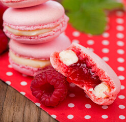 French makarons cake . Pink raspberry macaron cookies on dark wooden boards