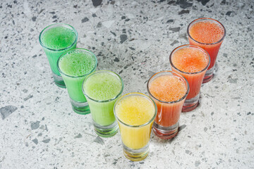 rainbow cocktail on a gray stone bar counter