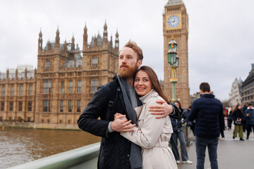Happy young traveler couple hugs against the background of Big Ben