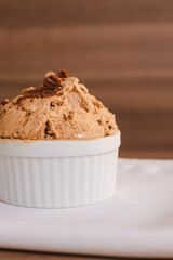 A cup of light chocolate ice cream with crushed chocolate cookies.