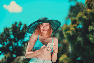 Young sexy filipina receiving a message and giggling about it. Grinning with her teeth. Wearing a...