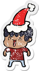 distressed sticker cartoon of a laughing boy wearing santa hat