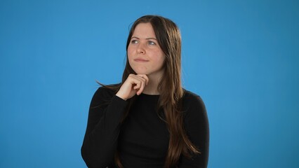 Portrait of thinking, smart puzzled pensive young brunette woman 20s wears black shirt looks around...