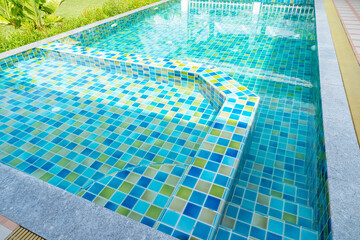 Obraz premium The Macro from Swimming pool with clear blue water in a garden area, surrounded by plants