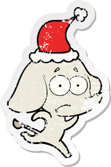 distressed sticker cartoon of a unsure elephant running away wearing santa hat