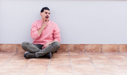 young handsome man sitting on the floors with a copyspace