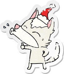 howling wolf distressed sticker cartoon of a wearing santa hat