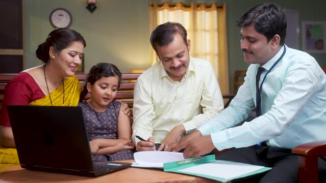 Bank officer taking sign from husband while sitting with family for insurance policy documents at home - concept of future investment, consultant and professional occupation.