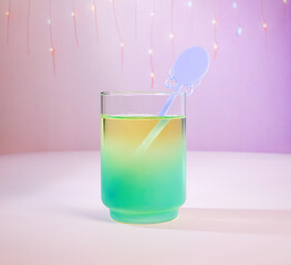 A Pastel Spring Cocktail: A Multi-Color Green and Yellow Beverage Drink with a Light Purple Ornate Swizzle Stick with Fairy Lights and Purple Background