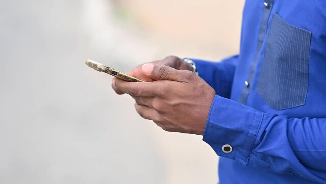 Plan your trip for convenience and savings, booking a taxi, chatting with friend and family 4K cropped video of an african hand using his smartphone to chat, book ride on the street of Lagos