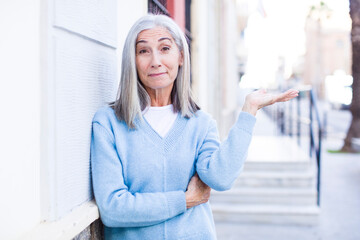 Fototapeta premium senior retired pretty white hair woman smiling proudly and confidently, feeling happy and satisfied and showing a concept on copy space