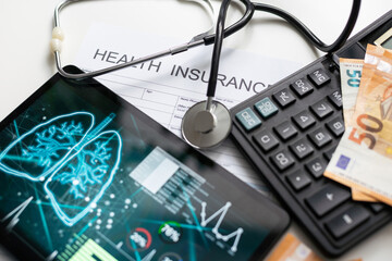 Modern social health insurance program. Tablet computer with healthcare application interface on screen. Stethoscope, x-ray image and cardiogram on wooden desk. Digital healthcare technologies