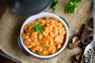 beans stewed with vegetables and spices, in a bowl .