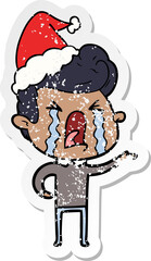 distressed sticker cartoon of a crying man wearing santa hat