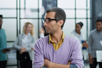 Young handsome man in elegant clothes and glasses looks away