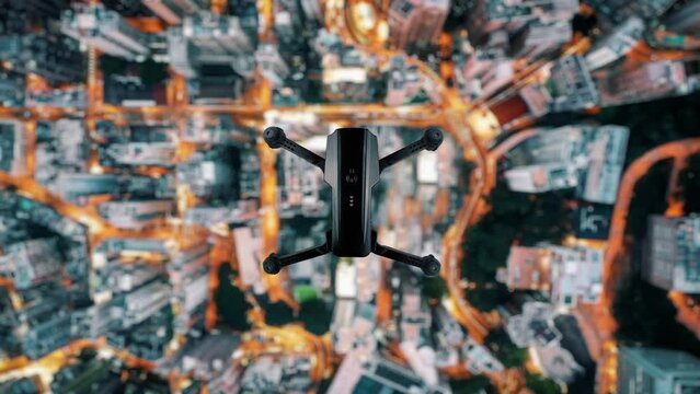 Quadcopter flying over the night city. Drone hovering in the air over houses. View from the top, seamless loop