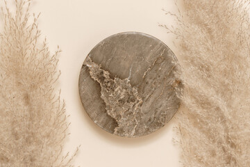 Marble background for product presentation with gentle pampas grass, beige tone. Aesthetic minimal empty podium top view