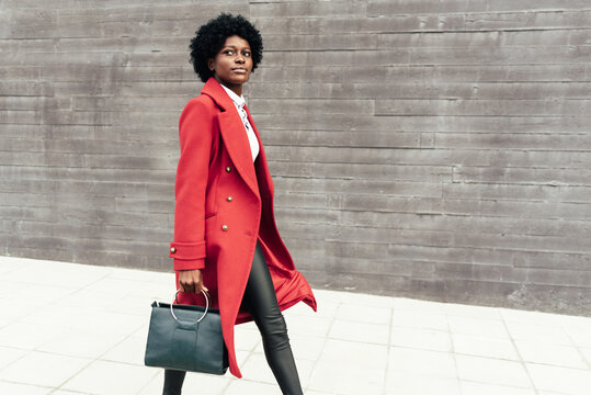 Stylish Afro Woman Looking Away While Walking Outdoors On The Street.