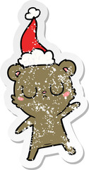 peaceful distressed sticker cartoon of a bear wearing santa hat