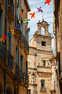 Beautiful medieval house stone facade and colorful garland in the old town of Pezenas in the south of France (Herault)