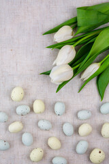White tulips and chocolate Easter eggs.