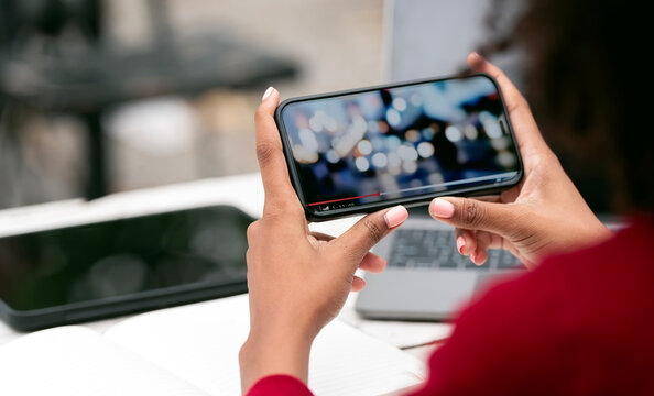 Cropped Shot Of Young Woman Watching Video On Her Smartphone In Horizontal View.