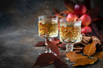 Glass of fresh cider with apple on dark background