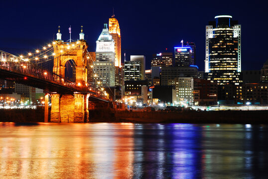 The lights of the buildings of the downtown Cincinnati business district are reflected in the water of the Ohio River