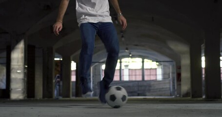 Low Angle, Ground Level Shot: Focus on the Legs of a Talented Young Soccer Athlete Juggling a Ball Skilfully. Man Showing His Freestyle Football Skills in an Underground Parking Lot, Doing Tricks