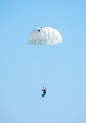 Skydiving. Flying parachutists against the background of the blue sky and mountains. Extreme sport and entertainment.