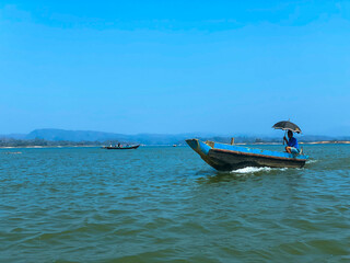 A boat with a man on it with an umbrella