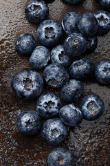 Fresh ripe blueberries with water drops on dark concrete background. Overhead view, close up