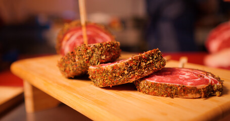 Row beef roulade cuts with skewers on a wooden cutting board. Barbecue preps seasoned with pepper mix. Cooking conept.