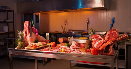 Wide view layout of various sausages and raw meat chunks. Wide range of meat goods on the table.