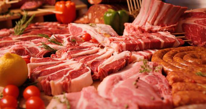 Delicious meat table layout raw steaks and sausages. Premium organic meat to sell in market. Meat industry concept.