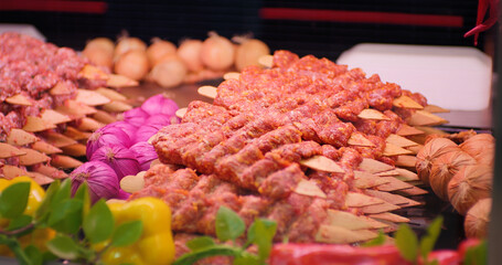 Close up traditional turkish raw kebab in a window shop for sale. Skewered lamb meat for kebab in a...