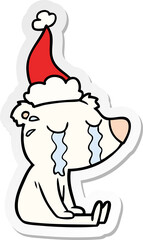 sticker cartoon of a crying sitting polar bear wearing santa hat