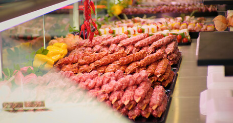 Freshly prepared turkish kebab on skewers layout in a shop. Close up traditional turkish raw kebab in a window shop for sale.