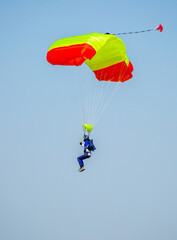 Skydiving. Flying parachutists against the background of the blue sky and mountains. Extreme sport and entertainment.