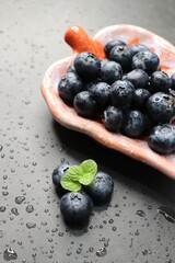 Fresh blueberries with mint leaves. The fruits are actual berries with many tiny seeds and are deep indigo to black color when ripe. Copy space.