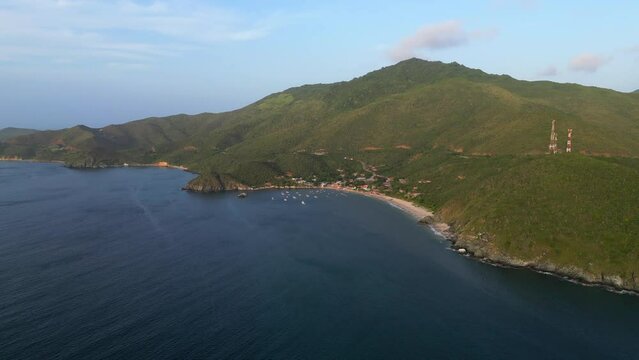 Aerial panoramic view of the coast of the Margarita island at dawn. Green mountains in the background and sandy beach with all inclusive resorts. Vacation in Venezuela 
