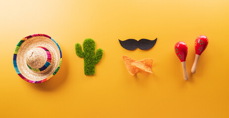 Cinco de Mayo holiday background made from maracas, cactus and hat on yellow background.