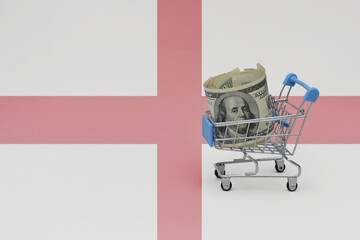 Metal shopping basket with dollar money banknote on the national flag of england background. consumer basket concept. 3d illustration