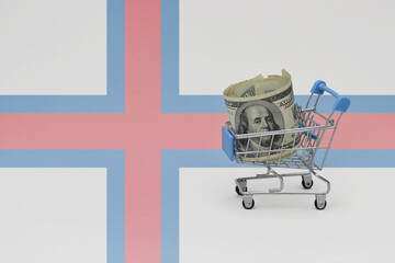 Metal shopping basket with dollar money banknote on the national flag of faroe islands background. consumer basket concept. 3d illustration